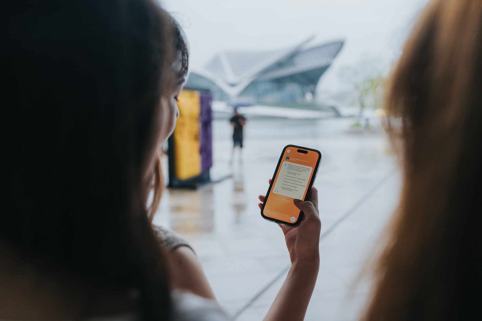 Happy Generation Z girls tavelling  in Zhuhai, Greater Bay Area, China, are looking for place to visit and asking advice from AI assistant  on a mobile app